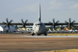 Untitled military transport plane at air base. Airport and airfield. Air force and army flight operation. Aviation and aircraft. Air lift. Military industry. Fly and flying. photo