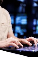 Close up shot of repairman dealing with server room system failures, using laptop to order supercomputers with high availability features to minimize downtime and prevent crashes photo