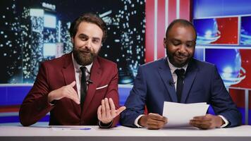 Night show hosts team presenting news during international television program, using important events on newscast to discuss about latest scandals. Diverse media journalists creating tv content. photo