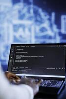 Licensed developer updates neural networks made up of interconnected nodes, writing intricate binary code scripts on laptop. Specialist uses programming to upgrade AI simulation model, close up photo