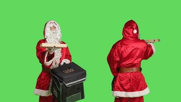 Man in costume delivering pizza in thermal backpack, portraying festive seasonal character in red suit over greenscreen background. December holiday celebration, bearded deliveryman. photo