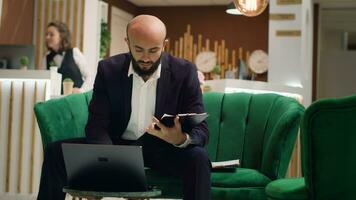 Entrepreneur in suit taking notes to create presentation at business meeting, travelling for event with corporate CEO. Executive manager working to do last minute changes on speech. Handheld shot. photo