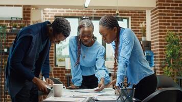 Colleagues discussing company solutions, examining papers with business statistics and results. Team of employees brainstorming ideas to create executive data report, annual boardroom collaboration. photo