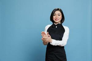 Cheerful asian waitress applauding and looking at camera with happy expression. Smiling joyful woman receptionist making applause, congratulating and celebrating success portrait photo