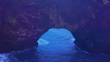 Rocky arch gate on icelandic peninsula, dyrholaey landmark with beautiful natural scenery and stone cliffs. Spectacular coastline rocks with majestic structure, landscapes. Handheld shot. photo