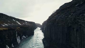 Drone shot of gullfoss waterfall canyon, amazing icelandic nature with huge river stream and massive rocky hills. Spectacular cascade in iceland running down off cliff. Slow motion. photo