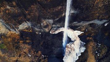 Drone shot of wild foss a sidu cascade, river flow running off frozen cliffs. Icelandic beautiful waterfall in iceland flowing down off mountains, fantastic panoramic landscape. Slow motion. photo