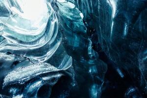 Majestic blue ice formations inside cave glowing covered in frost, transparent icy blocks in vatnajokull glacier crevasse. Glacial iceberg rocks forming natural winter setting in iceland. photo