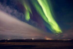 Beautiful aurora borealis sky in iceland, spectacular green and violet northern lights appearing at night creating panoramic landscape. Glowing magical natural phenomenon under starry sky. photo