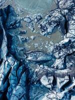 Drone shot of blue glacial rocks on vatnajokull ice mass in iceland, huge icebergs chunks with ice caves creating natural landscape. Breathtaking icy blocks within glacier lagoon. photo