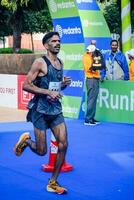 New Delhi, India - July 16 2023 - Vedanta Delhi Half Marathon race after covid in which marathon participants about to cross the finish line, Delhi Half Marathon 2022 photo