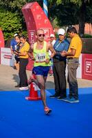 New Delhi, India - July 16 2023 - Vedanta Delhi Half Marathon race after covid in which marathon participants about to cross the finish line, Delhi Half Marathon 2022 photo