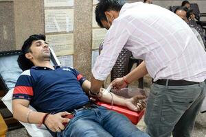 Delhi, India, June 19 2023 - Blood donor at Blood donation camp held at Balaji Temple, Vivek Vihar, Delhi, India, Image for World blood donor day on June 14 every year, Blood Donation Camp at Temple photo