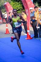 nuevo Delhi, India - julio dieciséis 2023 - vedanta Delhi medio maratón carrera después codicioso en cuales maratón Participantes acerca de a cruzar el terminar línea, Delhi medio maratón 2022 foto