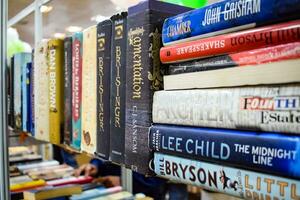 New Delhi, India, August 9 2023 - Variety of Books on shelf inside a book-stall at Delhi International Book Fair, Selection of books on display in Annual Book Fair. photo