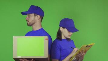 Cheerful delivery workers with a package smiling to the camera video