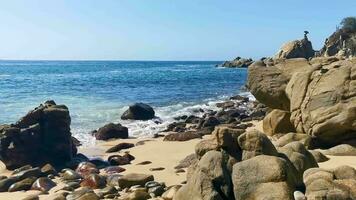 surfare vågor turkos blå vatten stenar klippor stenblock puerto escondido. video
