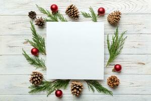 Flat lay Christmas composition. square Paper blank, pine tree branches, christmas decorations on Colored background. Top view, copy space for text photo