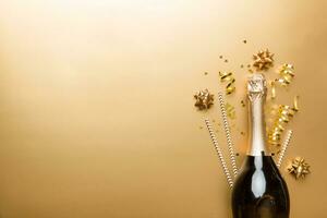 bottle of champagne with glasses and colorful confetti on colored background. top view flay lay photo