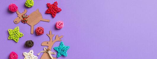 New Year decorations on purple background Banner . Festive stars and balls. Merry Christmas concept with empty space for your design photo