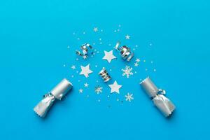 Christmas crackers with shiny confetti on color background, top view, copy space photo