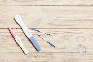 Colored Pregnancy test on wooden background, top view with copy space photo
