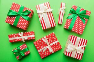 A lot of Christmas gift boxes in colored paper decorated on table, Top view close up. Many present New Year gift photo