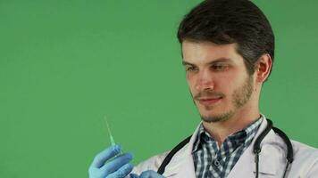 mannetje medisch arbeider Holding een injectiespuit Aan groen achtergrond video