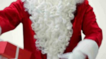 Santa holding and offering a gift close up video