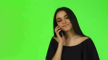 attraktiv ung kvinna i svart klänning talande på de telefon video