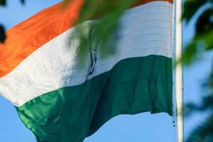 India flag flying high at Connaught Place with pride in blue sky, India flag fluttering, Indian Flag on Independence Day and Republic Day of India, tilt up shot, Waving Indian flag, Har Ghar Tiranga photo