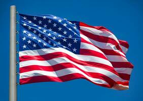 American flag waving in the wind against blue sky photo