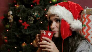 vrouw in santa's hoed drinken sommige drank video