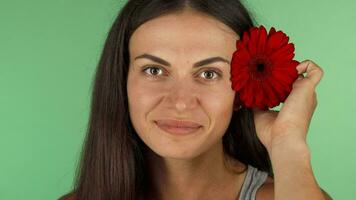contento joven mujer sonriente, poniendo flor en su pelo video