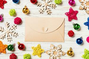 Top view of envelope on festive wooden background. Christmas toys and decorations. New Year time concept photo