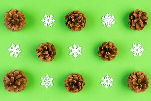 Top view of New Year ornament made of white snowflakes and pine cones on colorful background. Winter holiday concept with empty space for your design photo