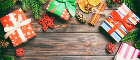 Top view of Banner Christmas background made of fir tree, gifts and other decorations on wooden background. New year holiday concept with copy space photo