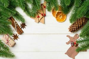 Top view of fir tree branches and festive decorative toys on wooden background. New Year time concept with empty space for your design photo