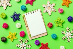 Top view of notebook. New Year decorations on green background. Festive stars and balls. Merry Christmas concept photo