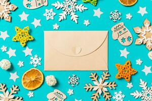 Top view of craft envelope on blue background with New Year toys and decorations. Christmas time concept photo