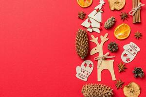 Top view of red background decorated with festive toys and Christmas symbols reindeers and New Year trees. Holiday concept with copy space photo