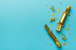 Christmas crackers with shiny confetti on color background, top view, copy space photo