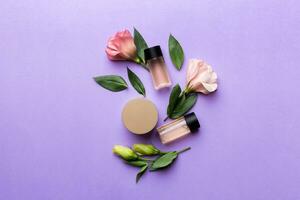 Composition with cosmetic products and beautiful roses on color background. Flat lay photo