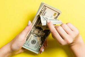 Top view of female hands counting money. Various dollar banknotes on colorful background. Salary concept. Bribe concept photo