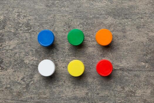 jars with gouache of different colors on Colored background. hobby painting. Top view with empty space. workplace for creativity. home teaching concept drawing photo