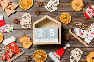 vista superior del calendario sobre fondo de madera de navidad. el veinticinco de diciembre. juguetes y decoraciones de año nuevo. concepto de vacaciones foto