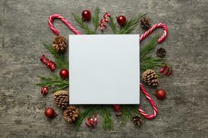 Flat lay Christmas composition. square Paper blank, pine tree branches, christmas decorations on Colored background. Top view, copy space for text photo