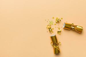 Christmas crackers with shiny confetti on color background, top view, copy space photo