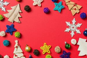 Top view of holiday decorations and toys on red background. Christmas ornament concept with empty space for your design photo