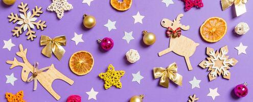Banner top view of New Year toys and decorations on purple background. Christmas time concept photo
